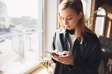 Image showing Young woman using gadgets to watch cinema, photos, online courses, taking selfie or vlog, online shopping