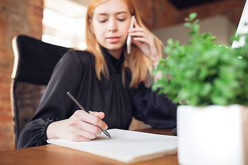 Image showing Caucasian young woman in business attire working in office