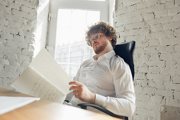 Image showing Caucasian young man in business attire working in office, job, online studying