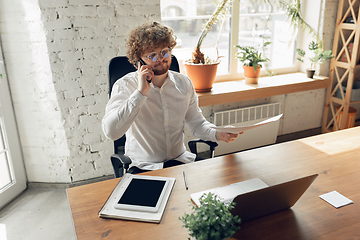 Image showing Caucasian young man in business attire working in office, job, online studying