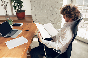 Image showing Caucasian young man in business attire working in office, job, online studying