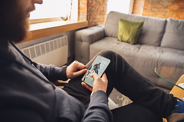 Image showing Young man using gadgets to watch cinema, photos, online courses, taking selfie or vlog, online shopping