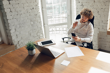 Image showing Caucasian young man in business attire working in office, job, online studying