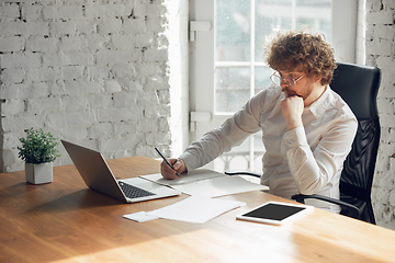 Image showing Caucasian young man in business attire working in office, job, online studying