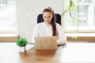 Image showing Caucasian young woman in business attire working in office