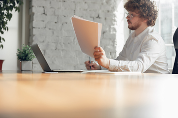 Image showing Caucasian young man in business attire working in office, job, online studying