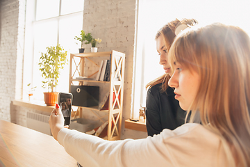 Image showing Young friends, women using gadgets to watch cinema, photos, online courses, taking selfie or vlog