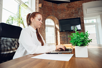 Image showing Caucasian young woman in business attire working in office