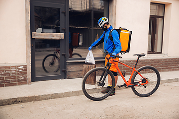 Image showing Contacless delivery service during quarantine. Man delivers food and shopping bags during isolation