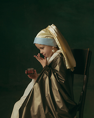 Image showing Medieval little girl as a lady with a pearl earring on dark studio background. Concept of comparison of eras, childhood. Stylish creative design, art vision, new look of artwork.