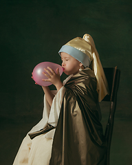 Image showing Medieval little girl as a lady with a pearl earring on dark studio background. Concept of comparison of eras, childhood. Stylish creative design, art vision, new look of artwork.