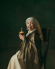 Image showing Medieval little girl as a lady with a pearl earring on dark studio background. Concept of comparison of eras, childhood. Stylish creative design, art vision, new look of artwork.