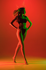 Image showing Beautiful female model on orange background in neon light. Beauty, cosmetics, spa, depilation, diet and treatment, fitness concept.