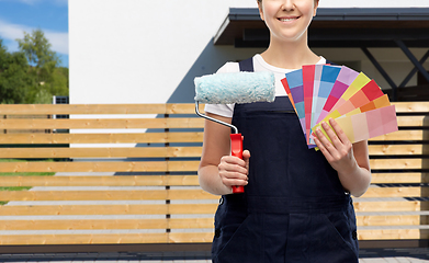 Image showing close up of painter with roller and color charts