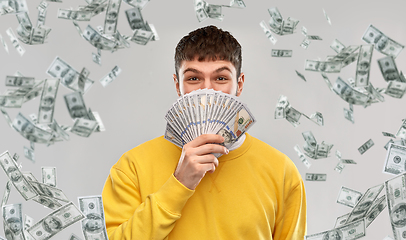 Image showing happy young man in yellow sweatshirt with money