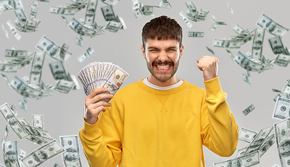 Image showing happy young man with money celebrating success