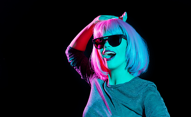 Image showing happy woman in pink wig and sunglasses dancing