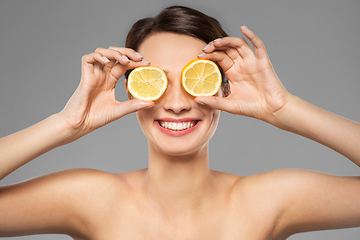 Image showing beautiful woman making eye mask of lemon slices