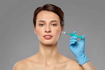 Image showing beautiful young woman and hand with syringe