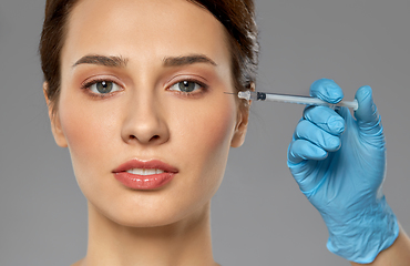 Image showing beautiful young woman and hand with syringe