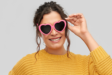 Image showing smiling young woman in heart-shaped sunglasses