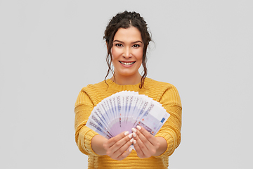 Image showing happy smiling young woman with euro money