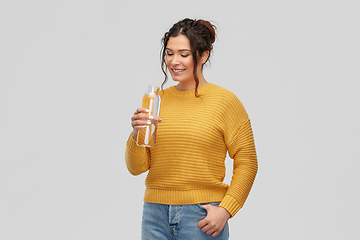 Image showing smiling young woman with water in glass bottle