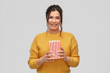 Image showing happy smiling young woman with bucket of popcorn