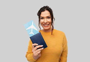 Image showing smiling young woman with passport and air ticket