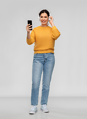 Image showing woman in headphones with smartphone