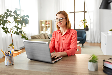 Image showing happy woman with laptop working at home office