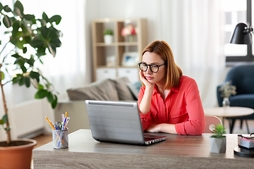 Image showing bored woman with laptop working at home office