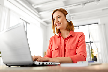 Image showing woman in headphones with laptop working at home