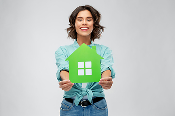 Image showing smiling young woman holding green house