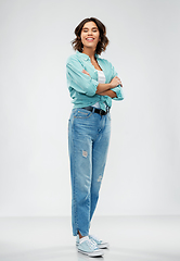 Image showing smiling young woman in turquoise shirt and jeans