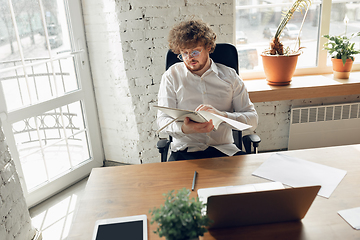 Image showing Caucasian young man in business attire working in office, job, online studying