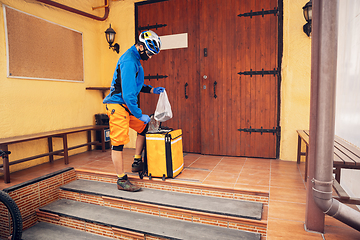 Image showing Contacless delivery service during quarantine. Man delivers food and shopping bags during isolation