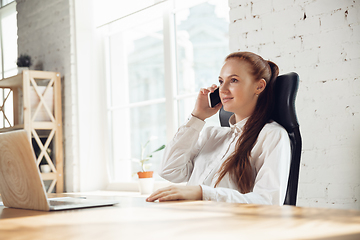 Image showing Caucasian young woman in business attire working in office