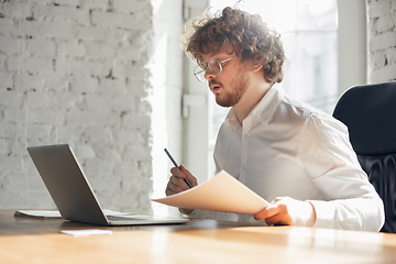 Image showing Caucasian young man in business attire working in office, job, online studying