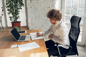 Image showing Caucasian young man in business attire working in office, job, online studying