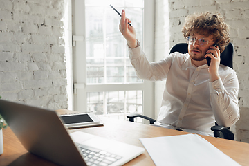 Image showing Caucasian young man in business attire working in office, job, online studying