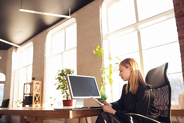 Image showing Caucasian young woman in business attire working in office