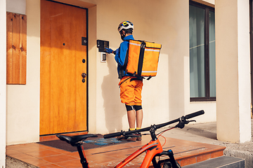 Image showing Contacless delivery service during quarantine. Man delivers food and shopping bags during isolation