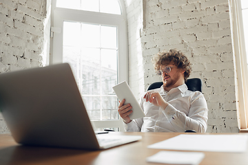 Image showing Caucasian young man in business attire working in office, job, online studying