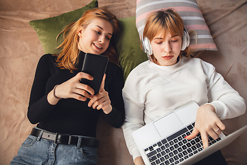 Image showing Young friends, women using gadgets to watch cinema, photos, online courses, taking selfie or vlog, top view