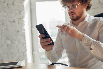 Image showing Caucasian young man in business attire working in office, job, online studying