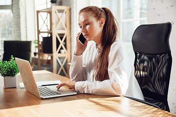 Image showing Caucasian young woman in business attire working in office