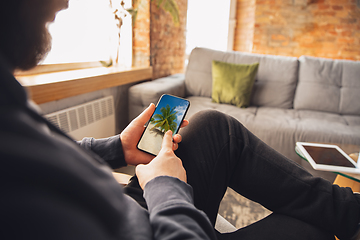 Image showing Young man using gadgets to watch cinema, photos, online courses, taking selfie or vlog, online shopping