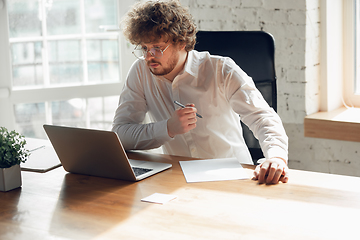 Image showing Caucasian young man in business attire working in office, job, online studying