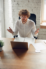 Image showing Caucasian young man in business attire working in office, job, online studying